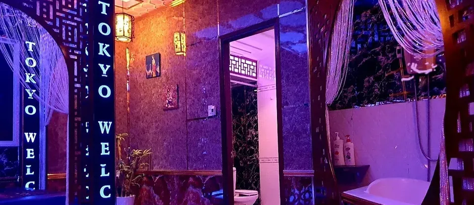 자갈 장식 욕조와 보라색 조명이 있는 도쿄 마사지실 내부