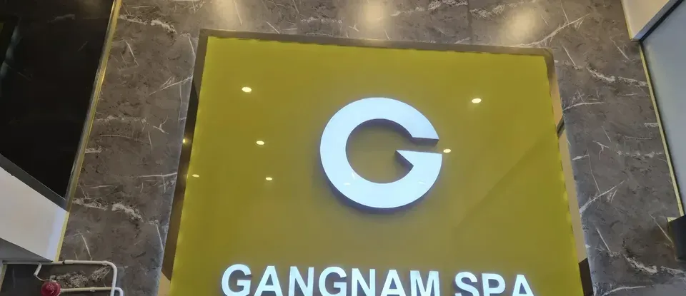 강남스파의 노란색 조명 로고 간판