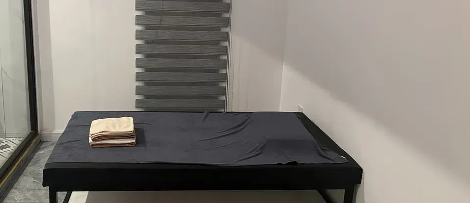 수건이 놓인 검은색 마사지 침대