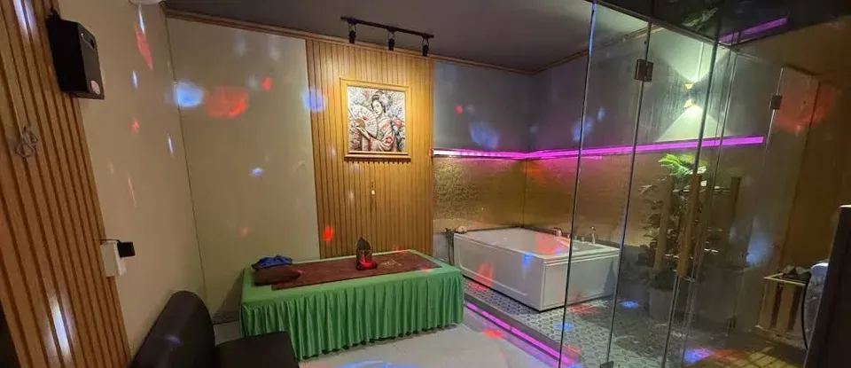 녹색 침대와 유리 샤워 부스가 있는 방