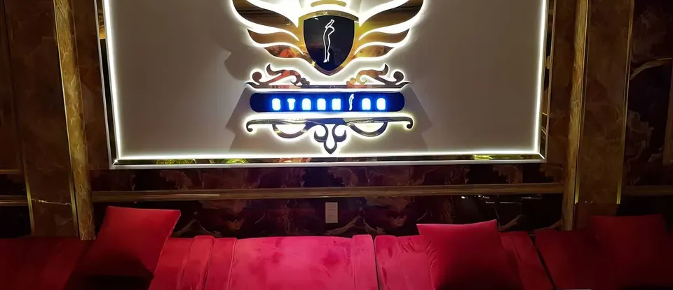 날개 로고 조명과 붉은 소파
