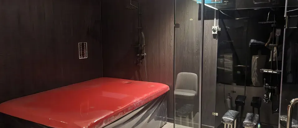 빨간색 매트와 샤워 시설이 있는 방