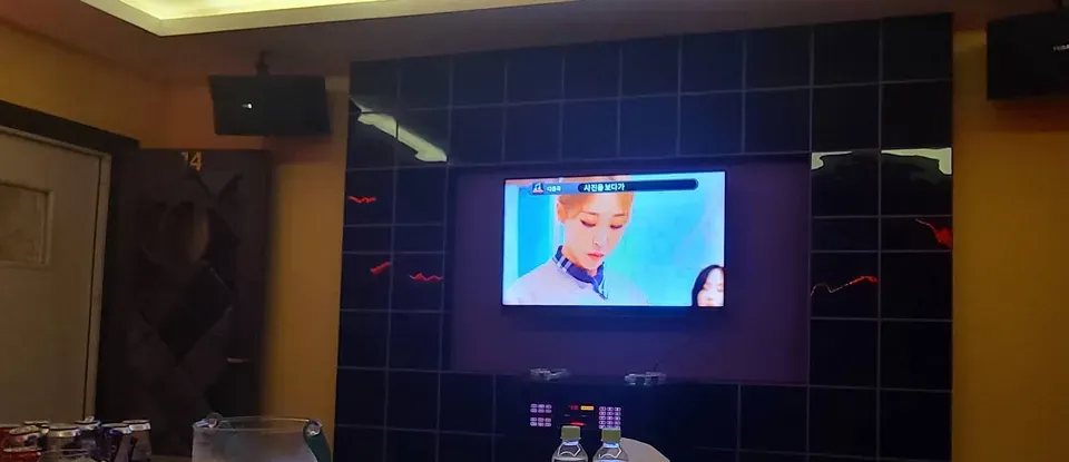 뮤직비디오가 상영 중인 대형 모니터와 테이블 세팅
