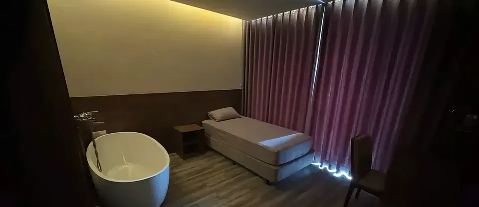 침대 옆에 욕조가 있는 마사지 룸