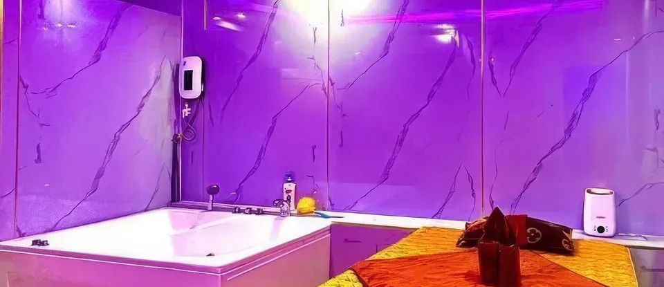 보라색 조명의 욕조와 마사지 베드